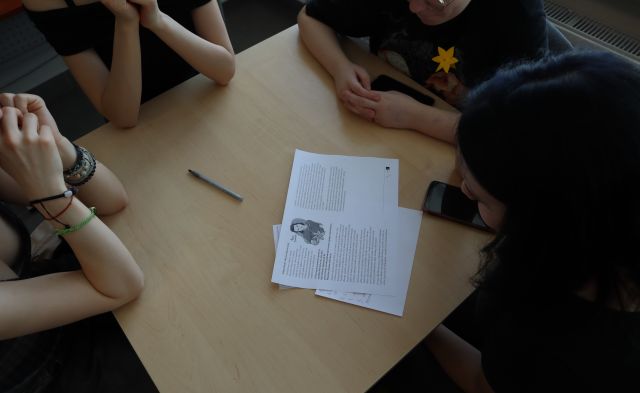 przy stolikach siedzi młodzież, na stoliku zapisane kartki