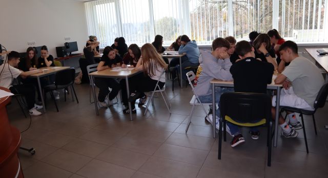 przy stolikach w sali komputerowej siedzi młodzież