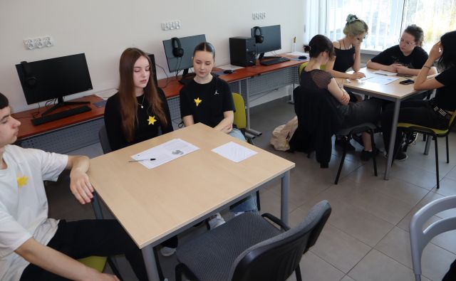 przy stolikach w sali komputerowej siedzi młodzież