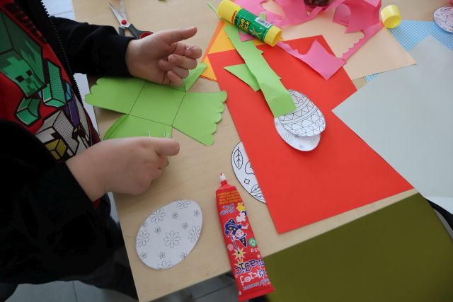 na stoliku kolorowe kartki i dłonie dziecka