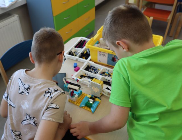 dwóch chłopców pochylonych nad klockami LEGO