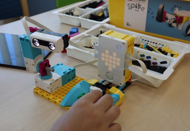 na zdjęciu dłońi model robota z klockó LEGO