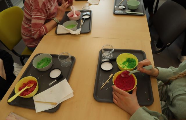 na stołąch plastikowe miseczki z kolorowymi masami