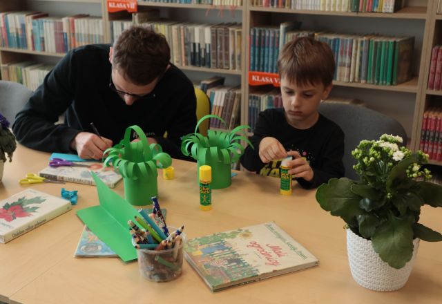 chłopiec z tatą wycinaja zielony koszyczek z kartek