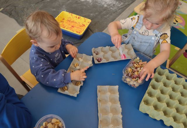 dzieci i mamy przekłądają kolorowy makaron po pudełęk po jajkach