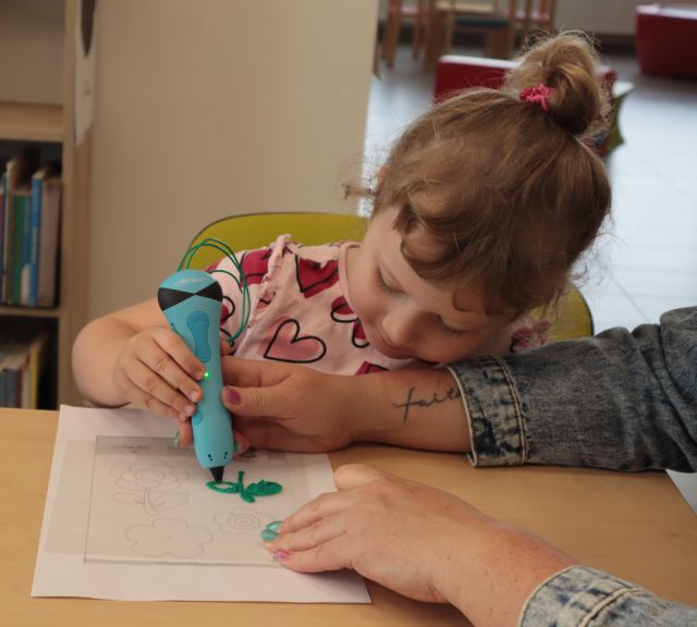 dziewczynka długopisem 3d maluje kwiatka