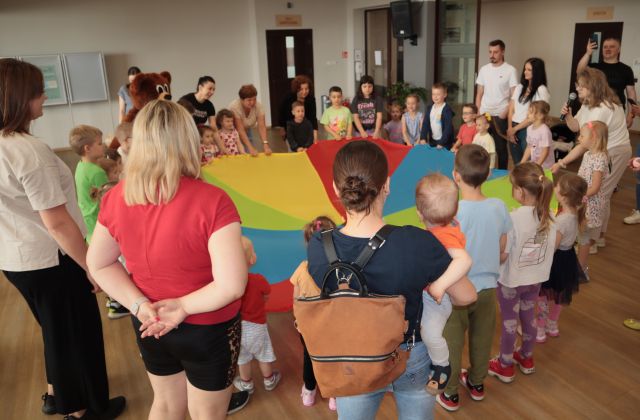 rodzice i dzieci trzymają chustę animacyjną
