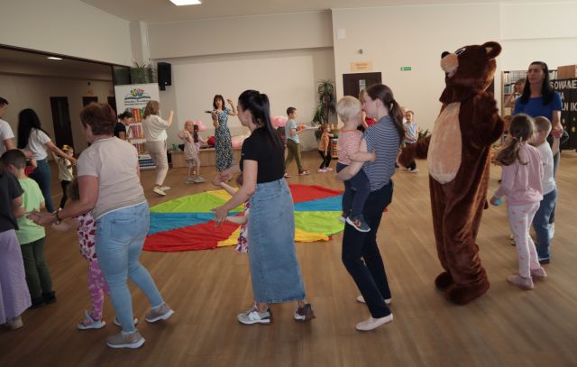 dzieci i rodzice chodzą w kółko wokół chusty animacyjnej