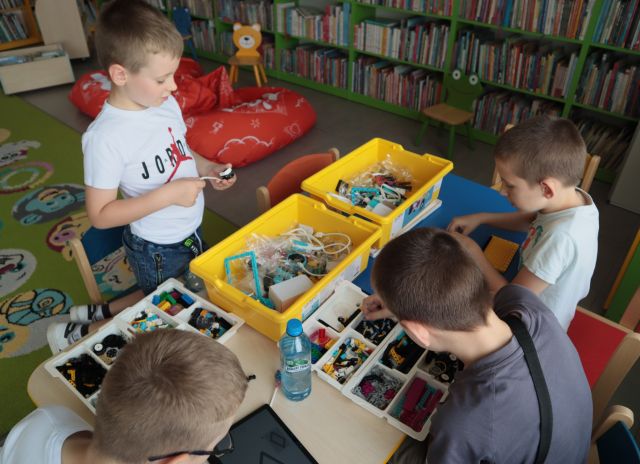 4 chłopców buduje z klockó Lego