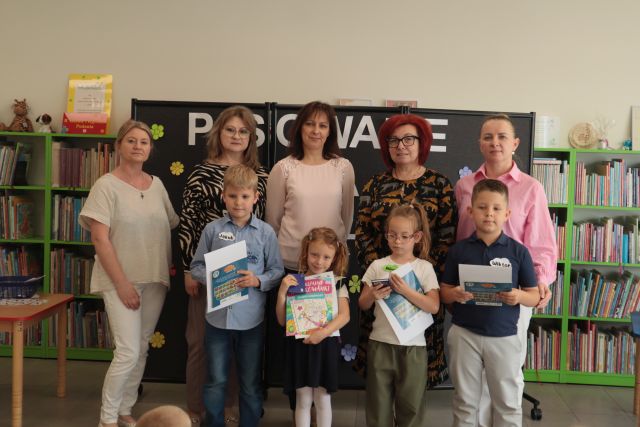 4 dzieci pozuje do zdjęcia z bibliotekarkami i nauczycielkami
