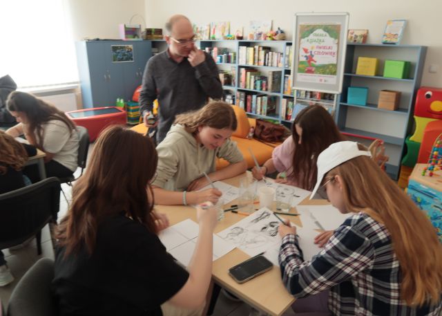 4 dziewczyny przy stoliku rysują komiks