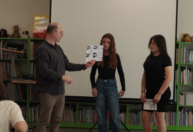 na zdjęciu mężczyzna z komiksem i dwie dziewczyny