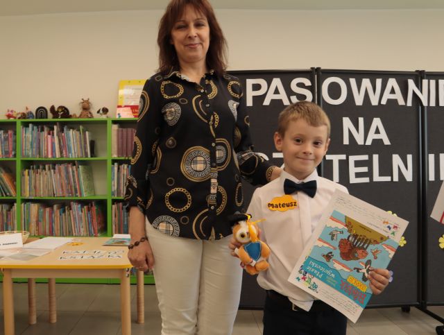 na zdjęciu dyrektorka biblioteki i chłopiec z książką i małą pluszową sówką