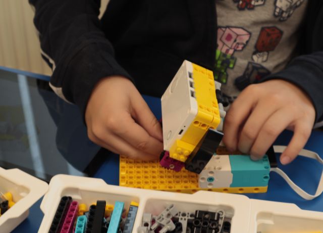 na zdjęciu dłonie skłądające klocki