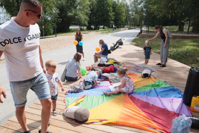 dzieci z rodzicami bawią się na chuście animacyjnej