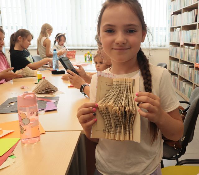 dziewczynka prezentuje sukienkę harmonijkową z książki
