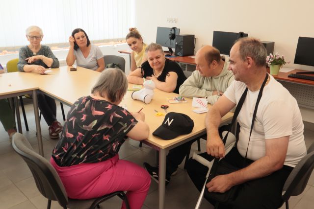 dorosłe osoby malują na kartkach