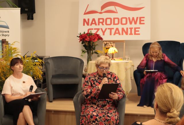 dwie kobiety siedzą w fotelach, na scenie siedzi aktorka