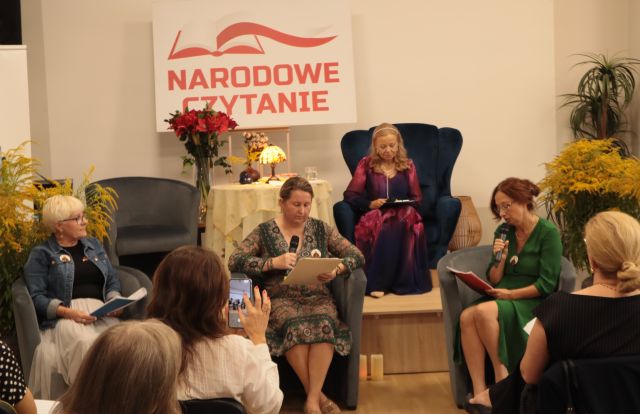 3 kobiety siedzą na fotelach, przed nimi na krzesłach siedzi publiczność, na scenie siedzi aktorka