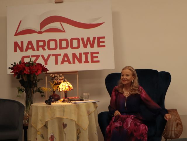 na zdjęciu aktorka siedząca na granatowym fotelu, w tle napis Narodowe Czytanie