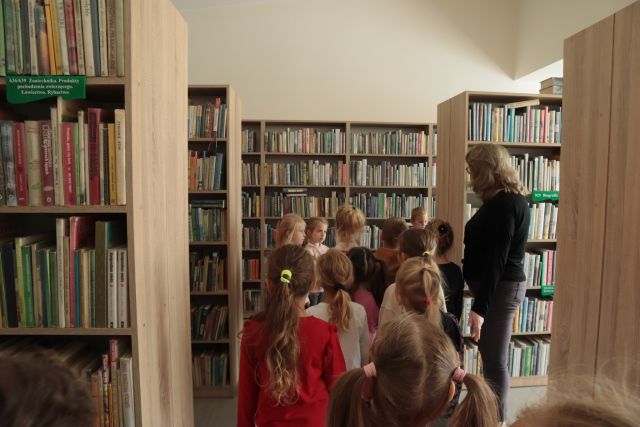 przedszkolaki w sali bibliotecznej w regałami