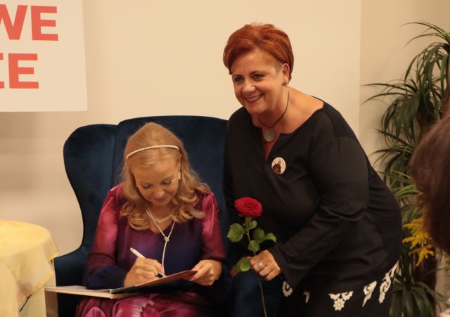 aktorka podpisuje książkęaktorka podpisuje książkę, na oparciu fotela siedzi kobieta