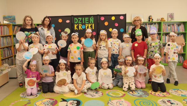 przedszkolaki pozują do zdjęcia z paniami i bibliotekarką