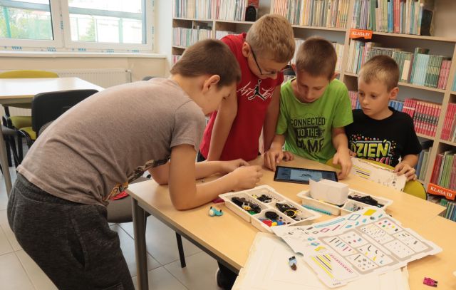dzieci programują robota na tablecie