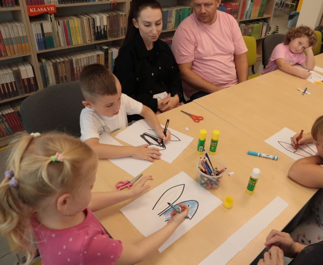 dzieci kolorują na kartkach królicze uszy
