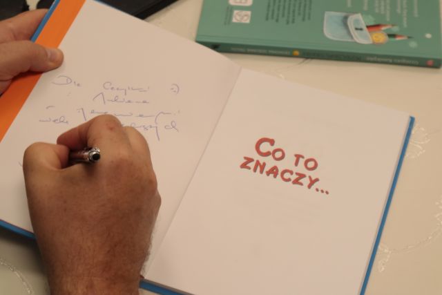 autor podpisuje książkę