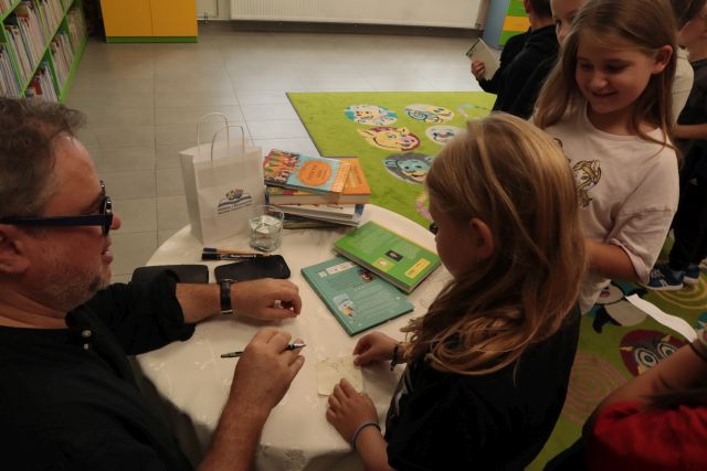 autor podpisuje dzieciom książki