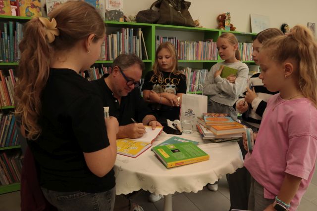 autor podpisuje dzieciom książki