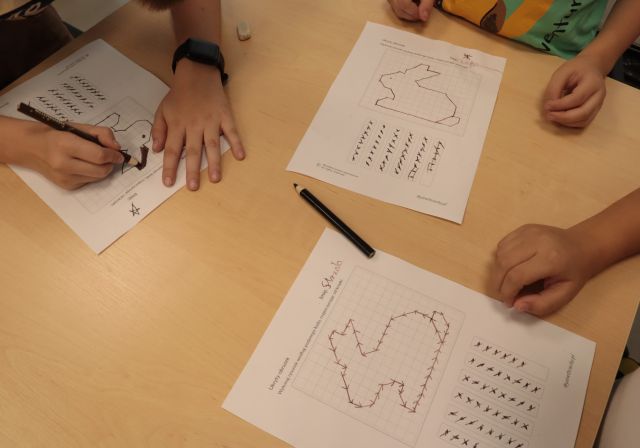 rozkodowane króliczki na kartkach i dziecięce dłonie