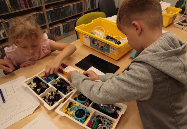 chłopiec i dziewczynka układają klocki Lego