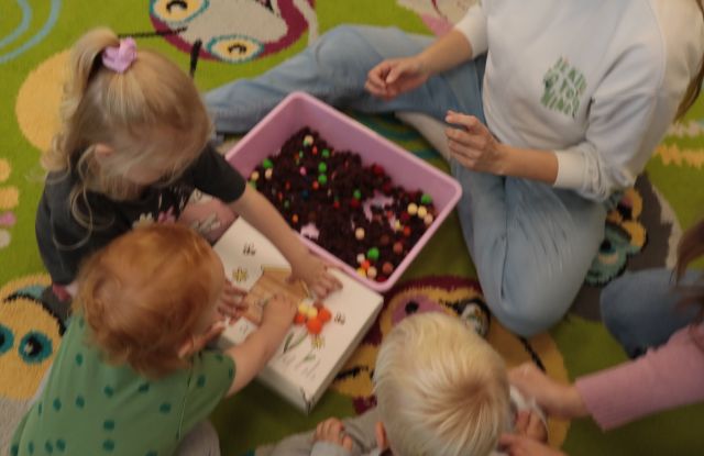 dzieci ukłądają kolorowe kulecki na pudełku