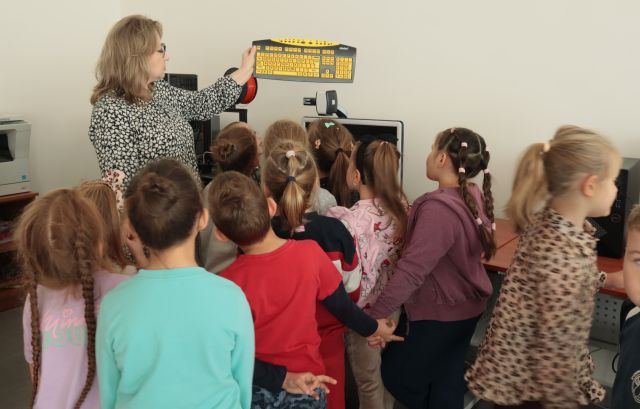 bibliotekarka pokazuje dzieciom żółtą klawiaturę