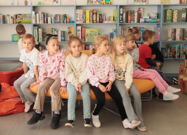 dzieci siedzą na okrągłej żółtej wyspie