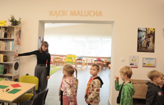 bibliotekarka i przedszkolaki przed wejściem do Kącika Malucha