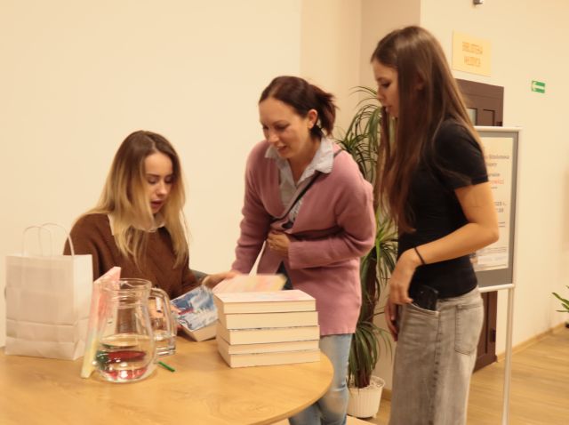 autorka podpisujedwóm dziewczynom książkę