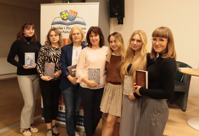 6 bibliotekarek z książkami pozuje do zdjęcia z autorką