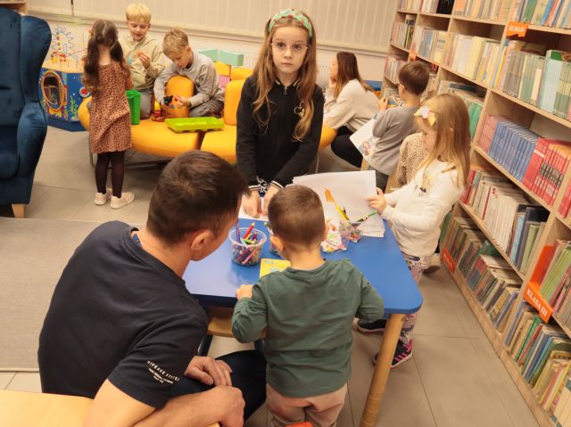 dzieci bawią się klockami i rysują przy stolikach