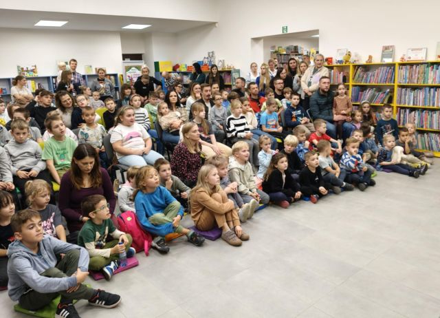 na zdjęciu uczestnicy spotkania ze zwierzakami siedzący na podłodze i krzesłach