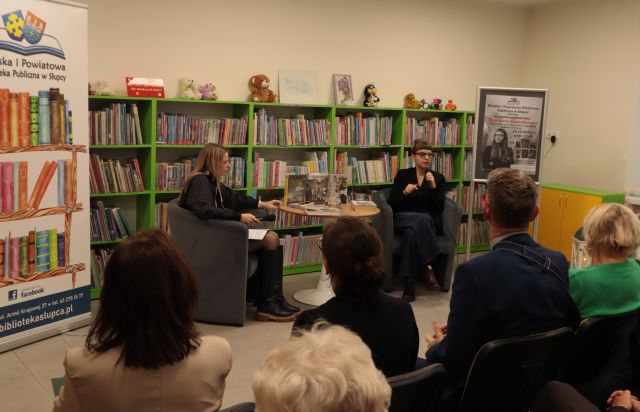 dwie kobiety siedzące przed widownią na krzesłach