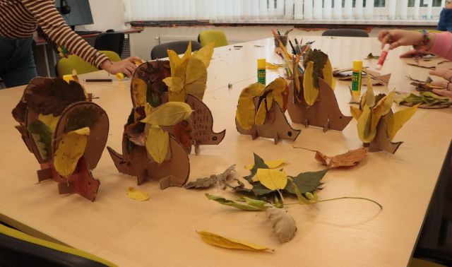 jeże z kartonów ustawione na połączonych stołach