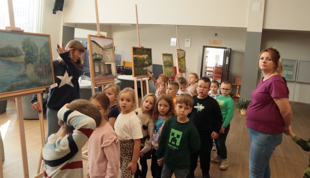 przedszkolaki przed obrazami w holu biblioteki