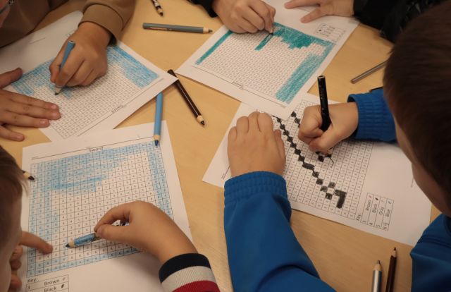 dłonie rysujące na kartkach