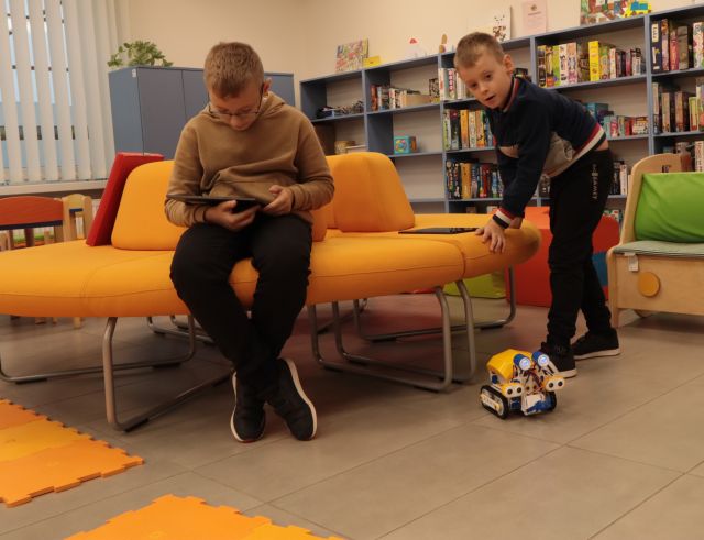 dwóch chłopców steruje robotem skribot