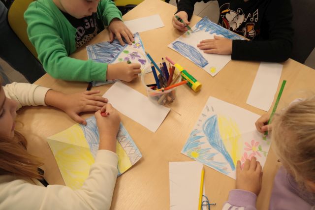 dziecięce dłonie malujące na kartkach