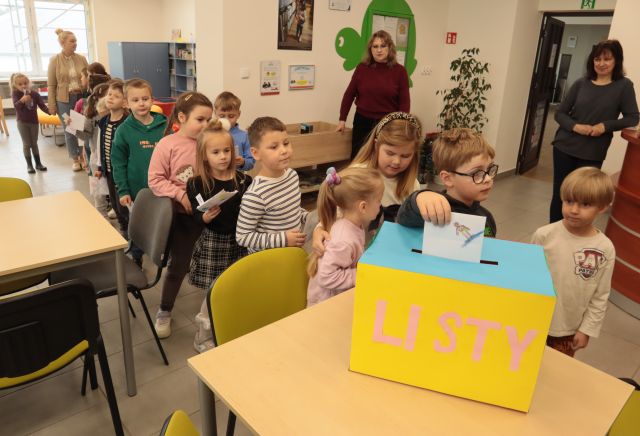 przedszkolaki wrzucają listy do skrzynki pocztowej z kartonu