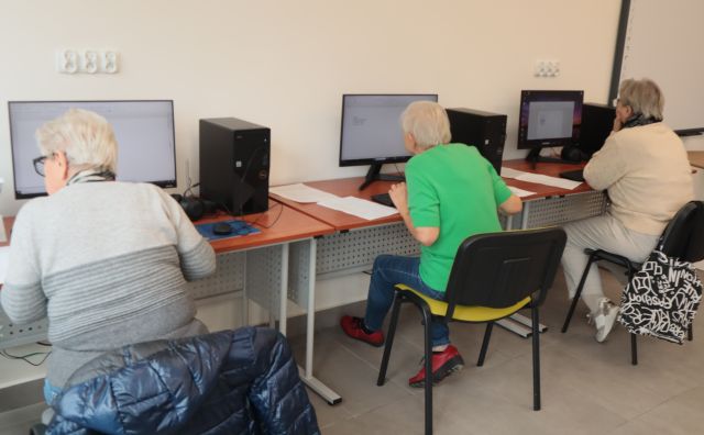 3 seniorów siedzi przy komputerach